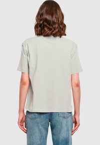 Lysegrå kortærmet t-shirt med en afslappet pasform og en glat bomuldsstrømpe, parret med lyseblå jeans med baglommer.