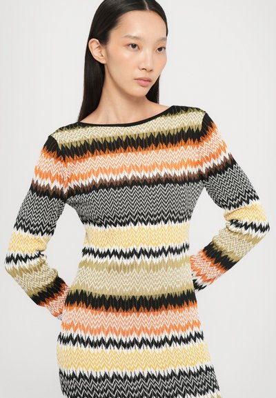 Abito in maglia con motivo zigzag arancione, nero, giallo, bianco e verde. Maniche lunghe e scollatura ampia. Materiale morbido e strutturato.