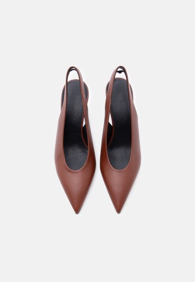 Καφέ δερμάτινα γόνατα με μυτερή μύτη και λουράκι στο πίσω μέρος, με μαύρες εσωτερικές σόλες, τοποθετημένα δίπλα δίπλα σε λευκό φόντο.