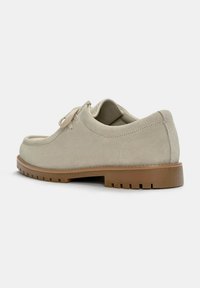Pantof light beige din suede, cu o formă rotunjită, design cu șireturi și talpă din cauciuc. Dispune de o textură netedă și detalii de cusătură minimaliste.