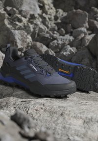 Čierne a modré turistické topánky s textúrovanou podrážkou a bočnými pruhmi. Majú odolný zvršok a gumovú podrážku Continental s dobrým gripom.