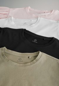Fire crewneck T-shirts i pink, hvid, sort og olivengrøn, pænt stablet med synlige halsmærker, der viser mærke og størrelse.