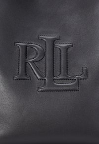 Melnas ādas soma ar iespiestu "RL" logo. Gluda tekstūra ar redzamām šuvju detaļām apkārt logo.