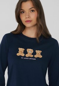 Námořnická dlouhá košile s třemi plyšovými ilustracemi medvídků různých výrazů a textem "MOJE TÝDENNÍ NÁLADA" v růžové barvě.