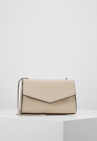 Borsa a tracolla in pelle beige con finitura testurizzata, chiusura a patta, bordi neri e tracolla a catena argentata. Logo impresso sul davanti.