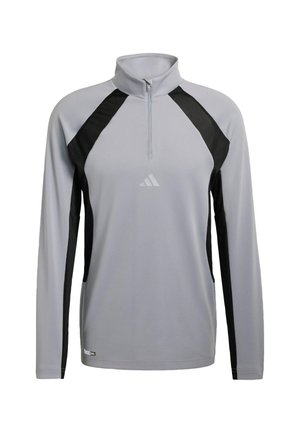 Jasnoszara, długorękawowa koszulka sportowa z czarnymi panelami bocznymi, zamkiem do ćwierć wysokości i małym logo Adidas na klatce piersiowej.