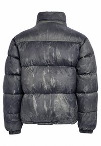 Fekete puffertakki matt felülettel, túlméretezett steppelt mintázattal, magas gallérral és enyhén kopott jelölésekkel. Puha, könnyű és meleg.