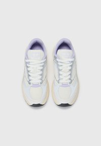 Scarpe sportive con tomaia leggera in mesh bianco con accenti lavanda, intersuola crema e suola esterna in gomma nera testurizzata.