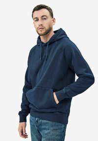 Felpa blu navy realizzata in tessuto morbido, con tasca a marsupio, polsini a coste e cordino regolabile sul cappuccio.