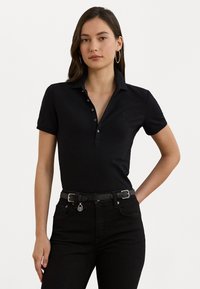 Svart polo skjorte med knapplukking, korte ermer og krage. Kombinert med høyt liv svarte jeans med belte.