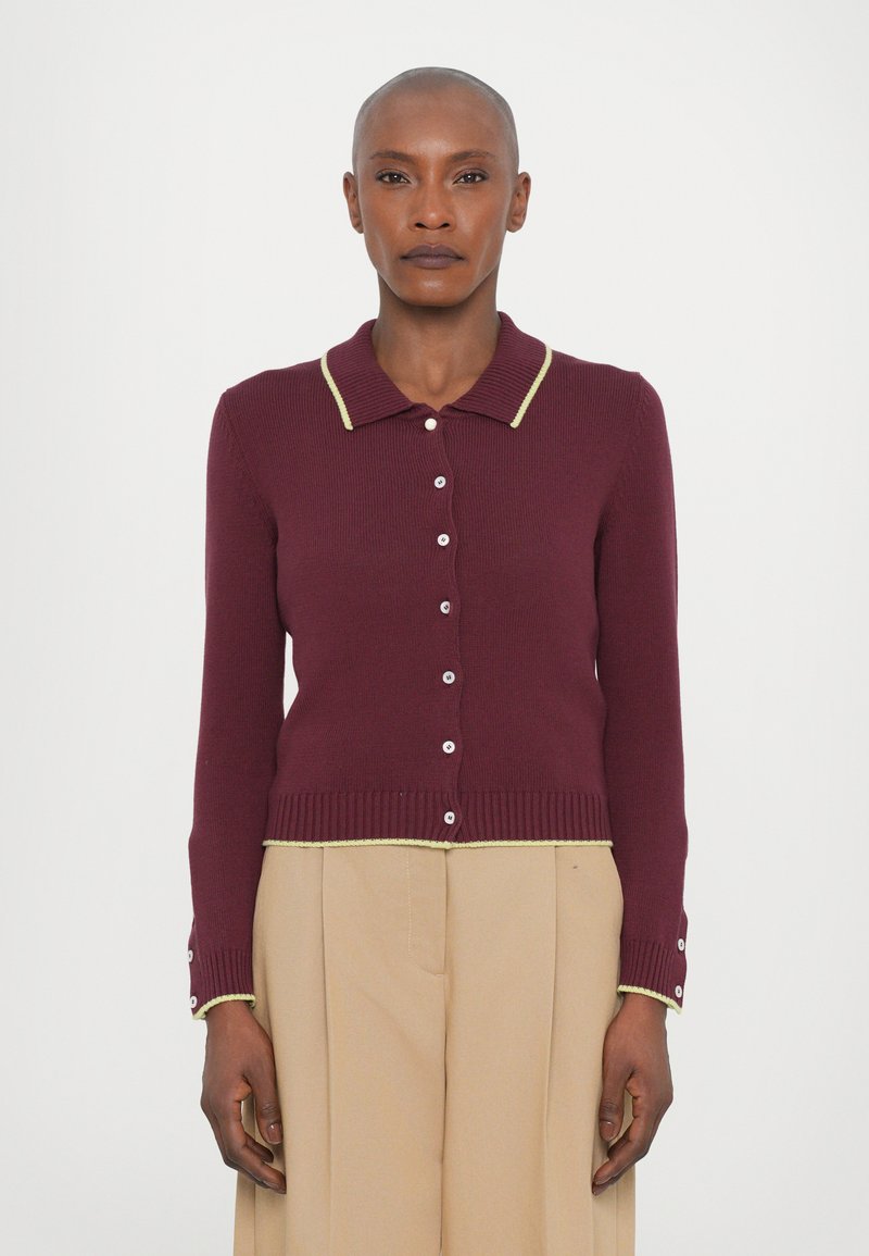 Cardigan tricoté bordeaux avec un col et une bordure jaune, doté de manches longues, de boutons sur le devant et d'un ourlet et de poignets côtelés.