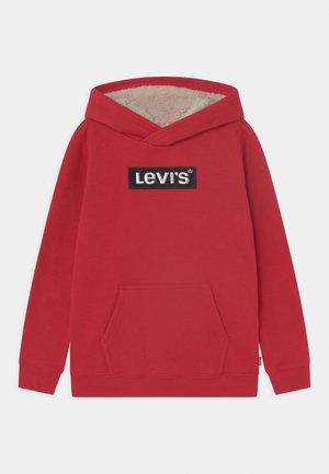 Hoodie rouge en tissu doux, avec capuche doublée crème, poche kangourou à l'avant et un patch logo rectangulaire Levis noir.