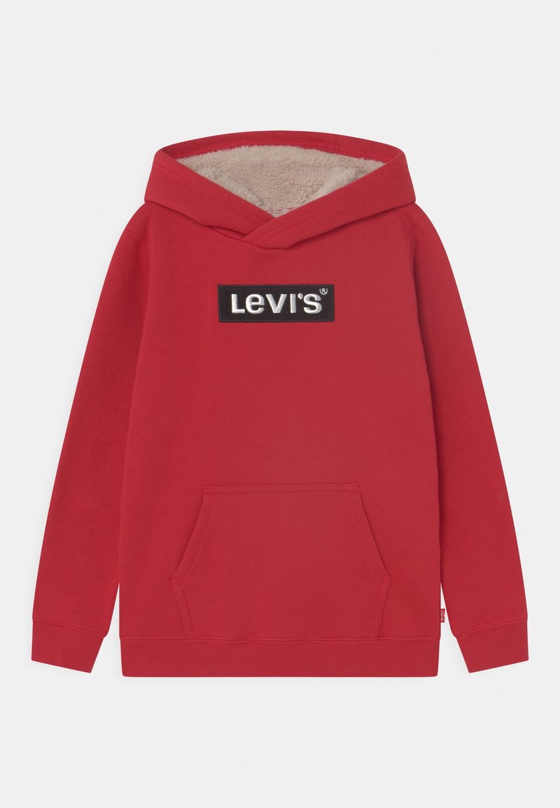 Hoodie rouge en tissu doux, avec capuche doublée crème, poche kangourou à l'avant et un patch logo rectangulaire Levis noir.