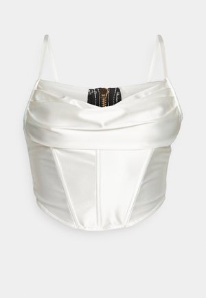 Haut corset en satin blanc avec de fines bretelles, présentant un design superposé et un détail de fermeture éclair noire à l'arrière. Texture lisse, forme structurée.