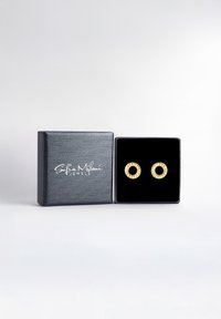 Guldörhängen med cirkulär design, försedda med klara ädelstenar. Presenteras i en grå box med svart sammetstoppning och strukturerad yta.