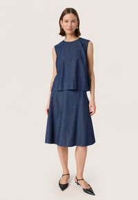 Denim two-piece outfit features a sleeveless top with a gathered neckline and a flared skirt, both in dark blue. Accented by ties.