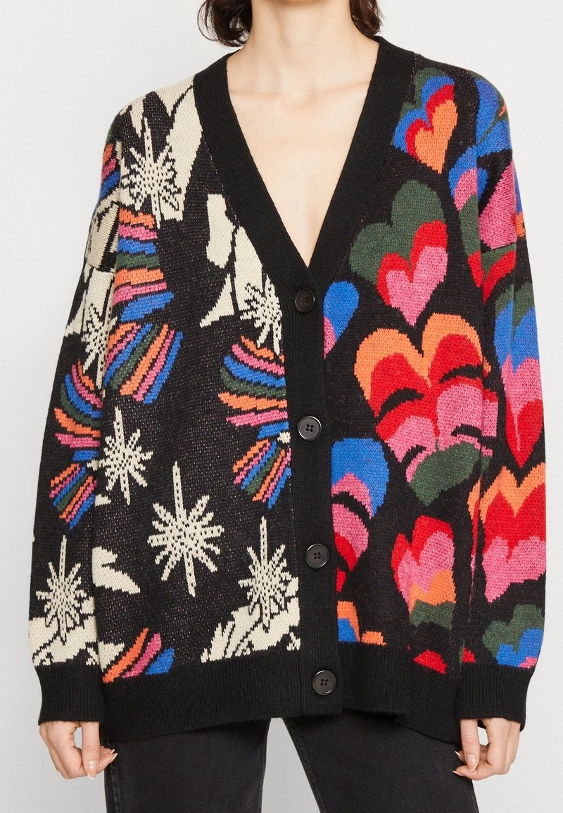 Strickjacke mit V-Ausschnitt, schwarzem Hintergrund und mehrfarbigen Herz- und Blumenmustern. Fünf schwarze Knöpfe vorne.