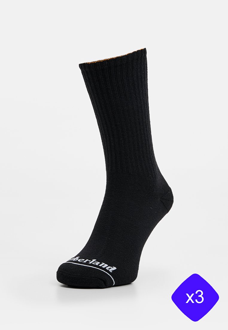 Calze nere a coste con design alla caviglia. Logo bianco del marchio sulla punta. Vendute in confezione da tre. Materiale in misto cotone.
