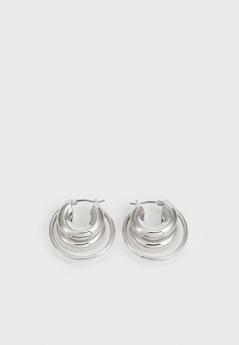 Silver hoop earrings featuring a layered design with three rings, smooth metallic texture, and secure hoop closure.