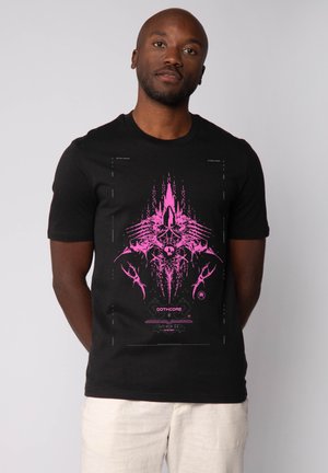 Zwarte katoen t-shirt met een groot roze grafisch ontwerp met abstracte vormen en tekst, korte mouwen en een ronde halslijn.