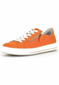 Baskets en daim orange avec des lacets blancs, détail de zip et une semelle en caoutchouc blanc avec une bande marron. Bout arrondi et design profilé bas.