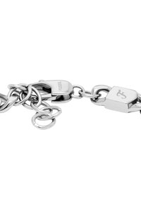 Pulsera de cadena de acero inoxidable plateado con eslabones entrelazados, que presenta un cierre de langosta y una etiqueta de marca con el logo grabado.