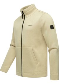 Beige ritsjack met hoge kraag, twee voorzakken en zwarte rits. Beschikt over een gestructureerde stof met een klein logo op de borst en de schouder.
