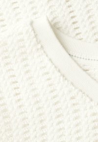 Bílý pletený svetr s texturovaným otevřeným tkaním, který má žebrovaný výstřih a měkký, nadýchaný materiál.