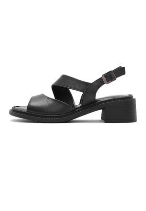 Sandale ouverte en cuir noir avec brides croisées, bride de talon réglable à boucle et petit talon carré sur fond blanc.