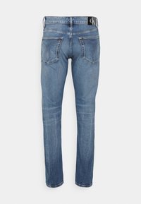 Blå denimjeans med rak benklipp, som har två bakfickor, en varumärkesetikett på midjan och subtila vintageblekningdetaljer.