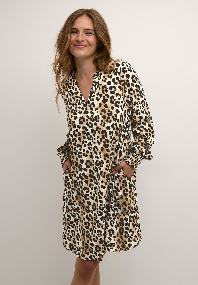 Beige- und schwarze Leopardenmuster-Kleid mit V-Ausschnitt, langen Ärmeln und Taschen; gestaltet mit einer lockeren Passform und glatter Textur.