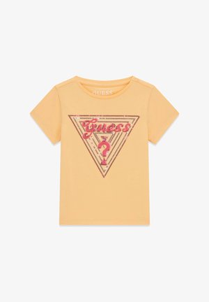 Chemise orange clair à manches courtes avec logo triangulaire Guess pailleté rose et point d'interrogation sur le devant.