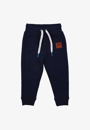 Navyblaue Jogginghose aus weichem Stoff. Mit ribbelten Bündchen, einem Kordelzug mit mehrfarbigem Muster und einem braunen Logo-Patch auf der Vorderseite.