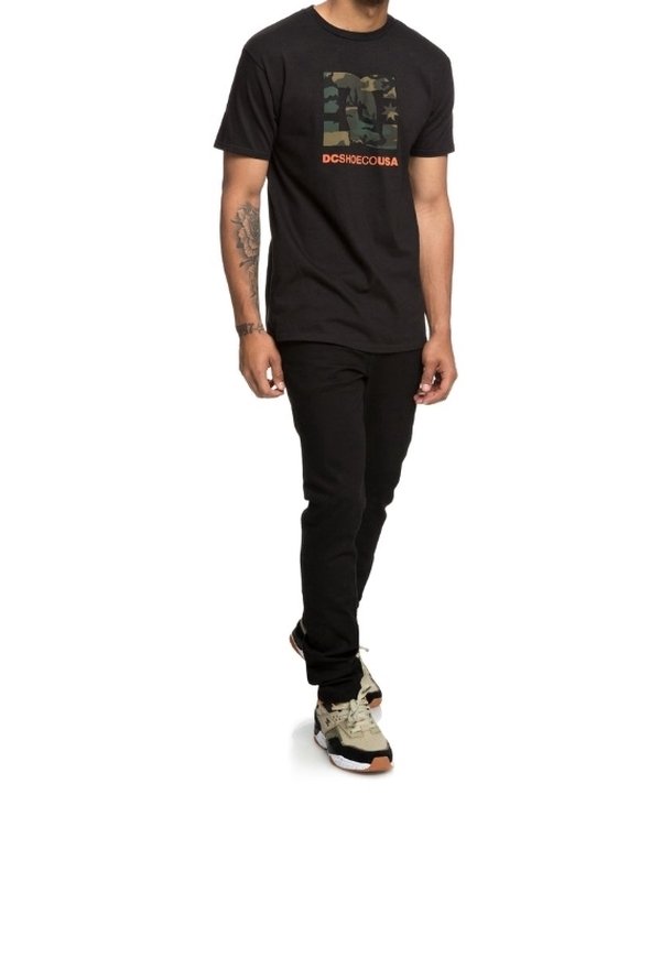 Black short-sleeve t-shirt featuring a camo graphic and orange text, paired with black pants and multicolored sneakers.