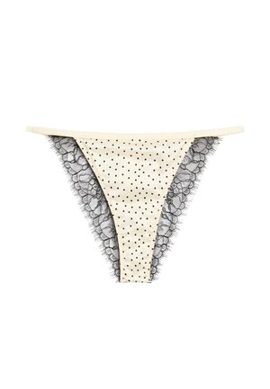Mutandine bikini da donna color crema con pois neri e bordatura in pizzo nero sui lati.