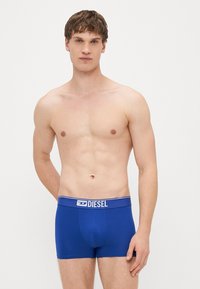 Μπλε βαμβακερό μποξεράκι με λευκή ελαστική μέση που φέρει το λογότυπο "DIESEL". Λεπτό υφή και εφαρμοστή σχεδίαση.
