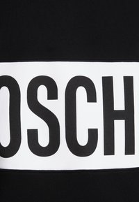 Felpa nera con una banda orizzontale bianca prominente su cui è stampato in grande testo nero "BOSCH". Tessuto liscio, design casual e estetica moderna.