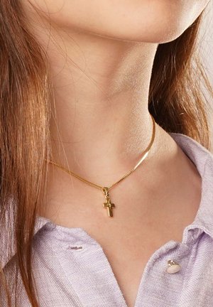 Goldene Halskette mit einer dünnen, glatten Kette und einem kleinen Kreuz-Anhänger, getragen an einem Hals mit langen braunen Haaren und einem helllila Hemd mit Kragen.