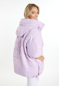Levandulová péřová bunda s velkou kapucí, oversized střih, prošívaná textura a zapínání na druky. Obsahuje boční kapsy a nastavitelné zakončení.
