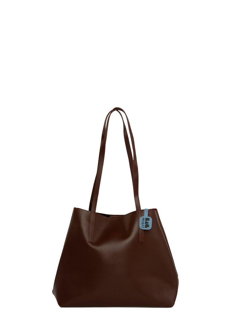 Geantă de umăr din piele maro, cu două mânere lungi, o textură netedă și o etichetă mică albastră atașată de unul dintre mânere. Design simplu, fără ornamente.