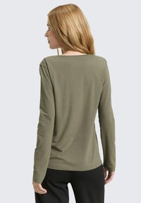 Overhemd met lange mouwen in olijfgroen, gemaakt van gladde stof. Heeft een brede halslijn en een getailleerde pasvorm, met een eenvoudig, strak ontwerp.