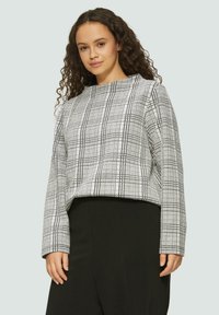 Gekürzter Pullover im schwarz-weißen Karo-Muster, mit rundem Ausschnitt und langen Ärmeln, aus einem glatten Material.