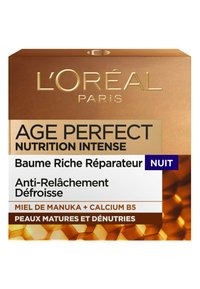 La boite de la crème de nuit L’Oréal Age Perfect présente un schéma de couleurs doré et marron, avec du texte en relief et des accents en motif de nid d’abeille.