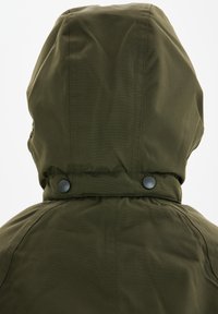 Olijfgroen jack met een capuchon, voorzien van knopen op de kraag en een gladde, gestructureerde stof met zichtbare naaddetails.