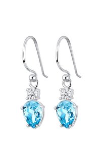 Boucles d'oreilles en argent avec deux cristaux bleus, un rond et un en forme de poire, accentués par une pierre claire au-dessus du cristal plus grand.
