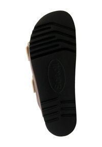 Semelle de chaussure en caoutchouc noir avec un motif de grip texturé. Présente des rainures latérales et un logo ovale de marque au centre.