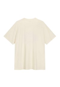 T-shirt surdimensionné de couleur crème en coton doux. Doté de manches courtes et d'un col rond. Design simple sans motifs ni accents.