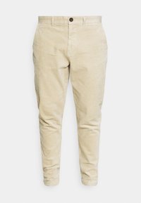 Pantalon en velours côtelé beige avec une coupe slim, présentant un tissu texturé, des passants de ceinture, un bouton à l'avant et des poches standard.