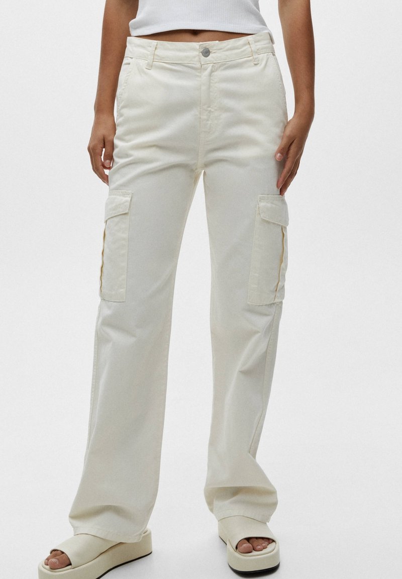 Pantalons cargo en coton crème, dotés de deux poches latérales, d'une coupe décontractée et d'une fermeture à bouton classique. Texture lisse avec des jambes droites.