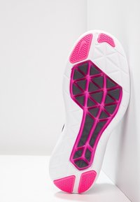 Suola della scarpa in gomma bianca con accenti rosa, motivo testurizzato e segmenti neri. Progettata per trazione e flessibilità.